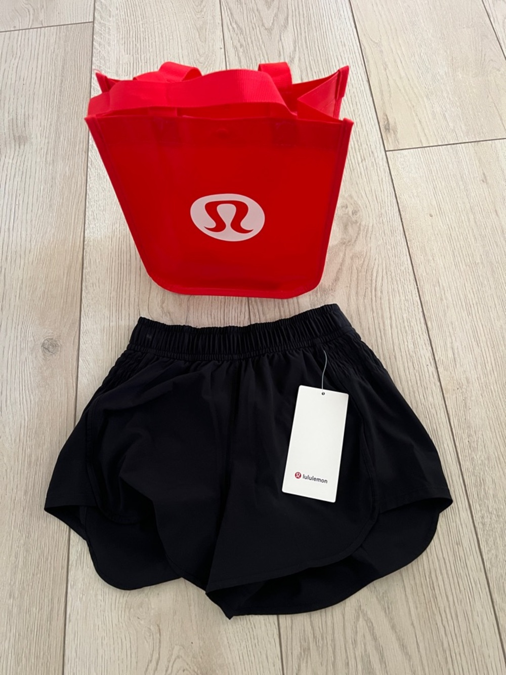 lululemon black running shorts with red branded tote